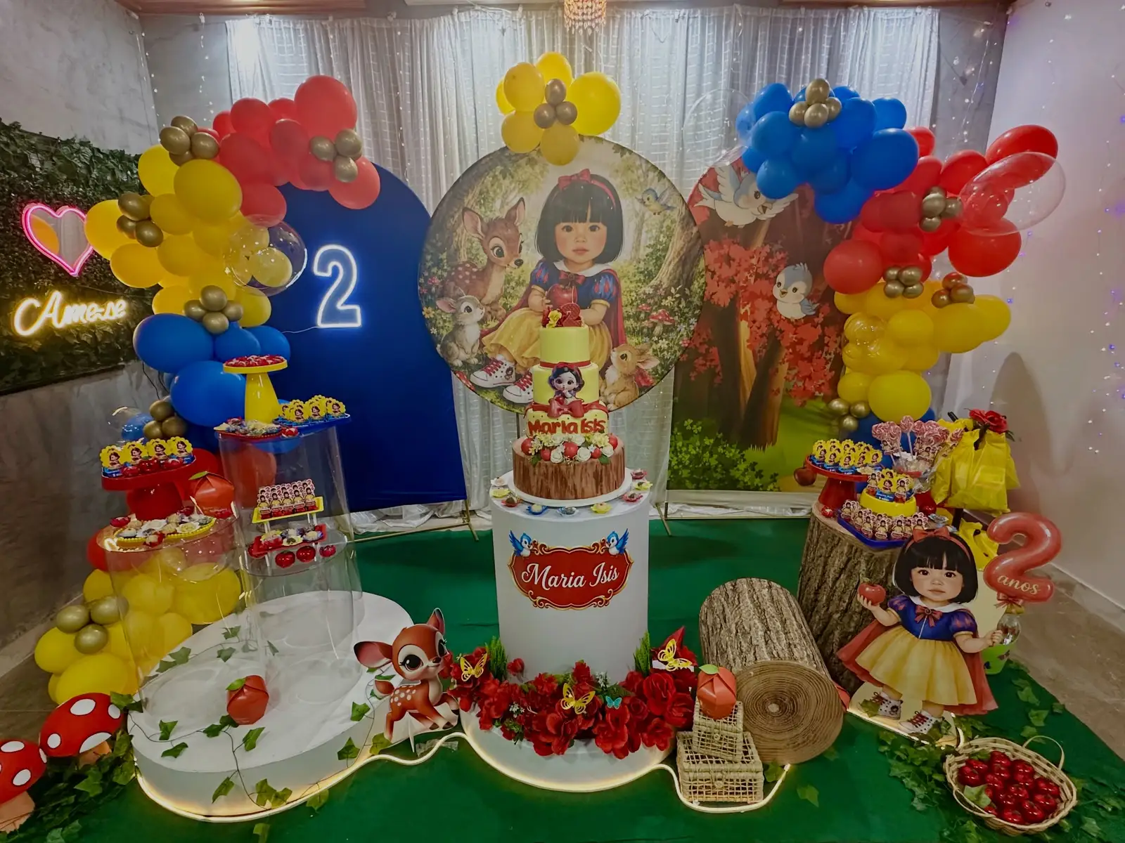 Aniversário com tema Branca de Neve: painel redondo, arcos de balões e mesa com bolo e doces