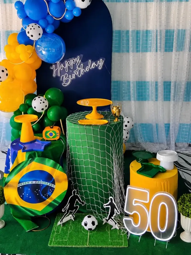 Decoração verde e amarela com bandeira do Brasil, bola de futebol e número 50 em neon