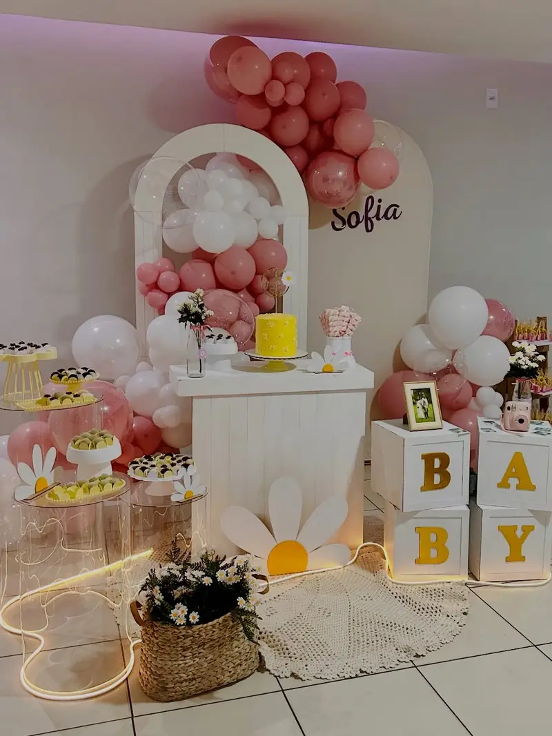 Chá de bebê com painel em arco, margaridas, balões rosa e cubos BABY